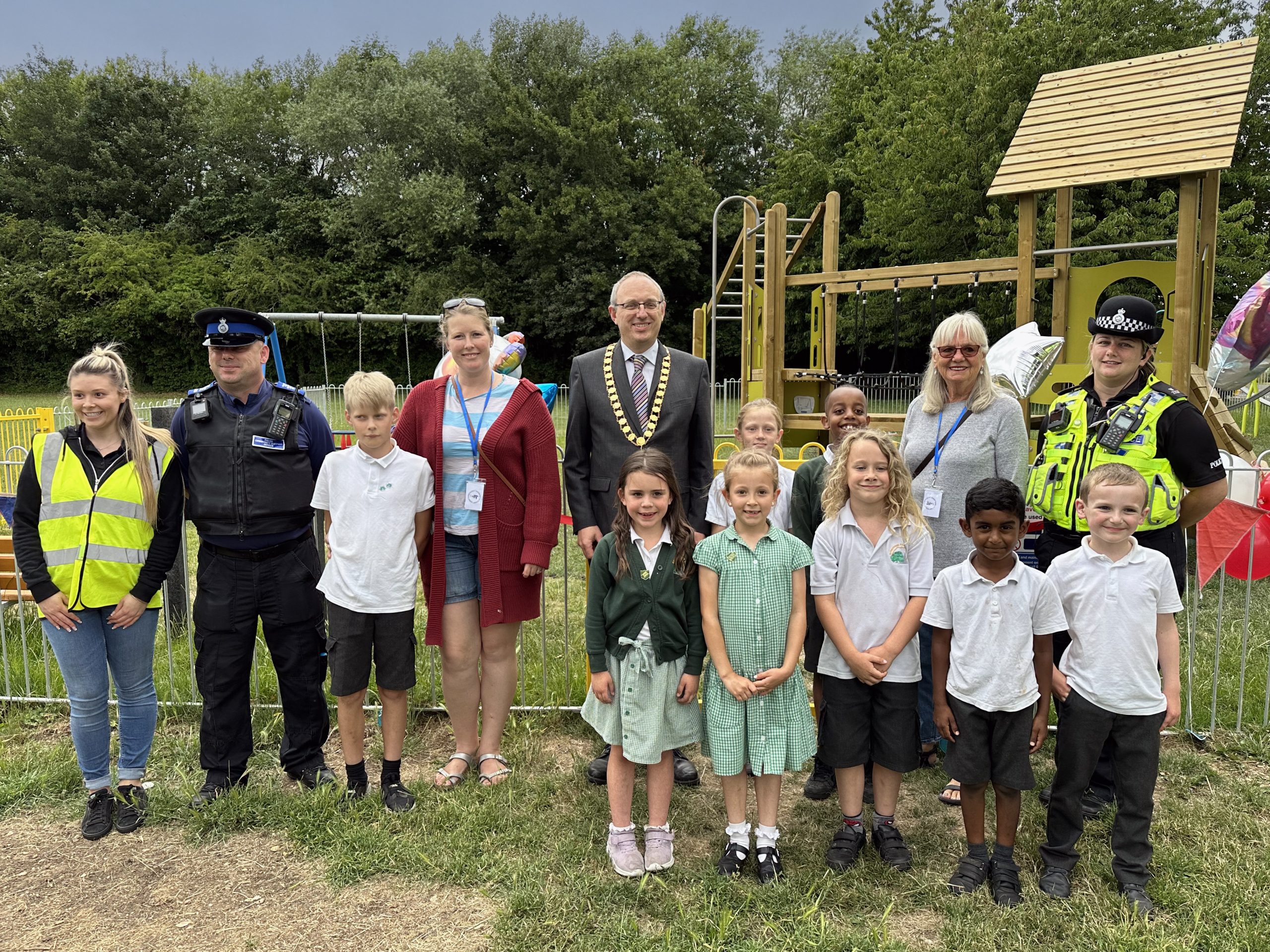 Nick Baker Chair of the Parish Council with Cllrs Waller and jones, Children from Greentrees Primary School, PC Rachel Gunn and PCSO Taylor, at the ribbon cutting for St Peters Play Park