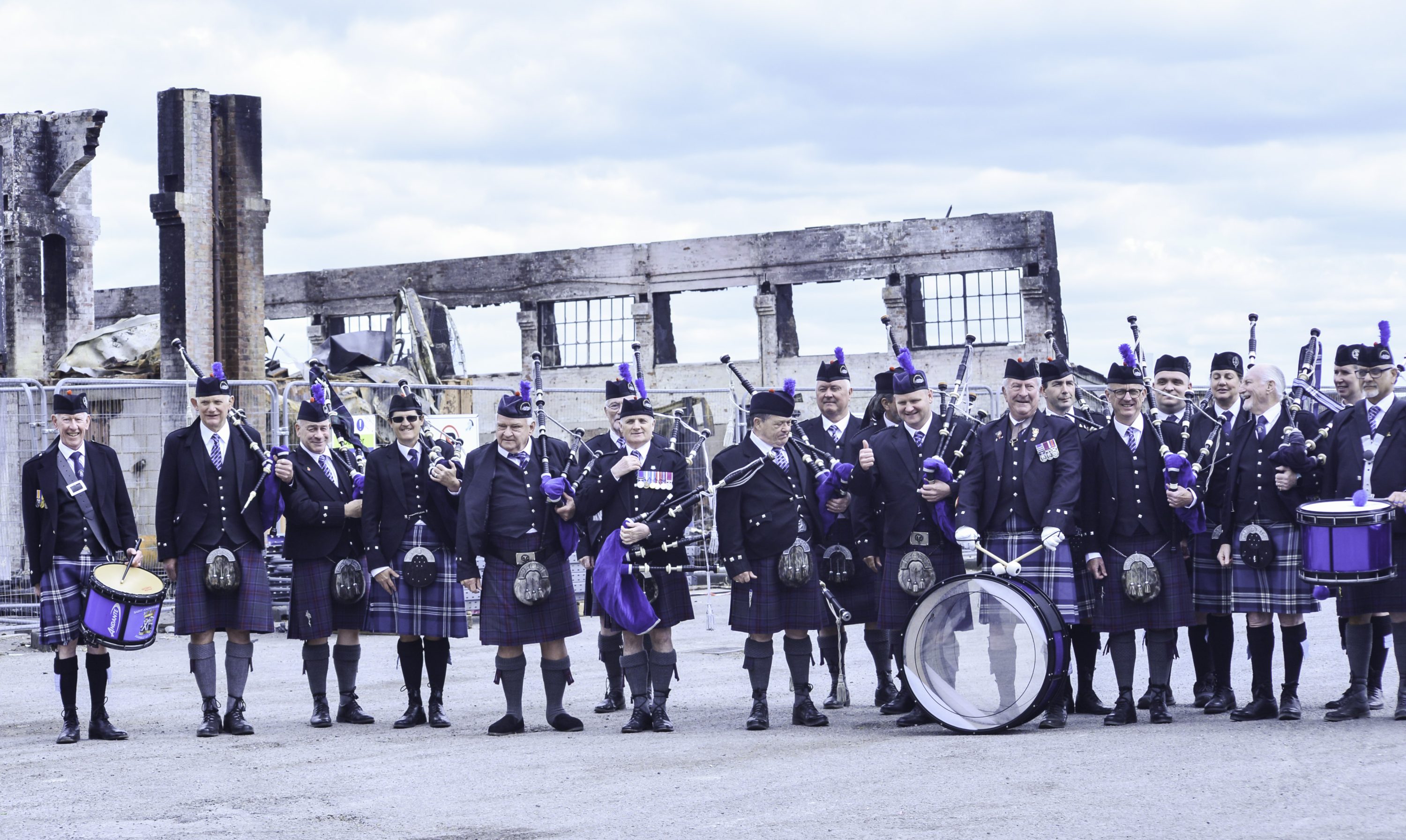 Wiltshire Caledonian Pipes and Drums at Old Sarum Air Field. Outside burnt out Hangar in 2025